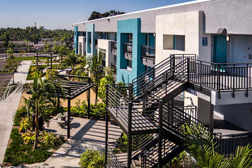 A building with a blue and white exterior and a black metal staircase.