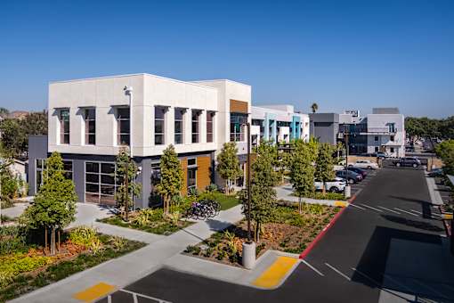 A modern building with a white facade and a yellow line on the road.