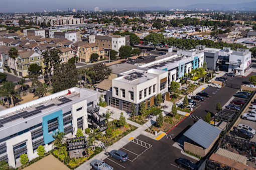 A parking lot is in the foreground of a city scene.