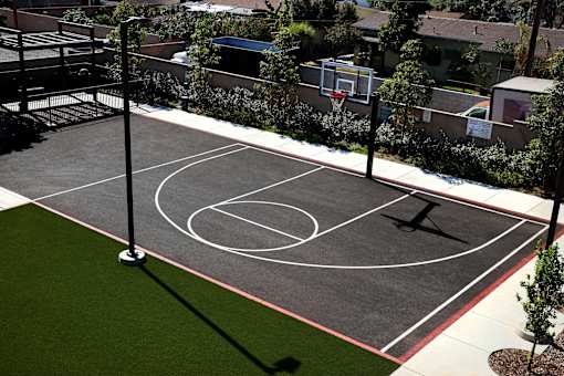 A basketball court with a green grass area in the middle.