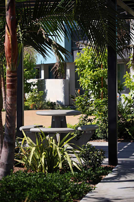 A table and chairs are set up under a canopy in a garden.