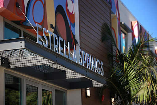 A sign that says Estrella Springs is hanging from a building.