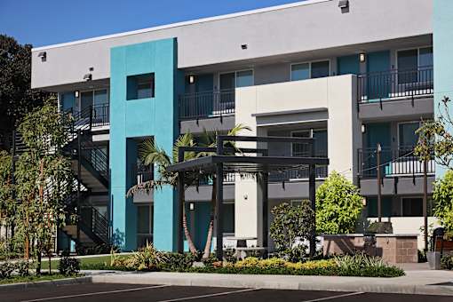 A modern building with a blue and white facade and a black metal staircase.