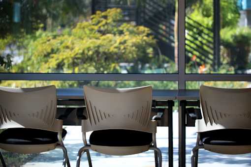 Four chairs are lined up in front of a window.