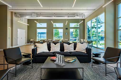 A modern living room with a black sofa and a coffee table.