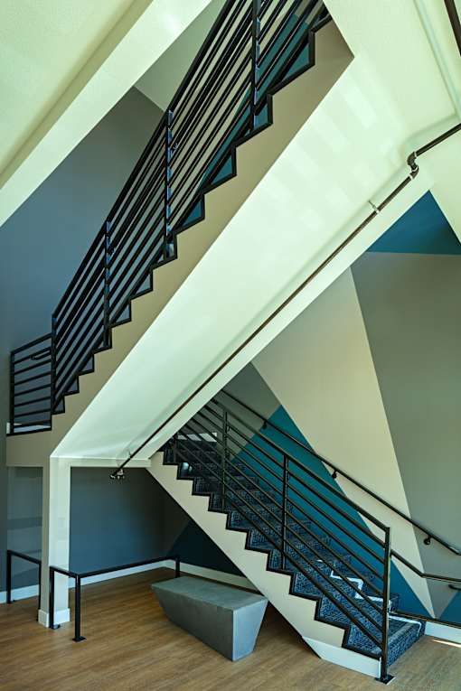 A staircase with a black railing and a white handrail.