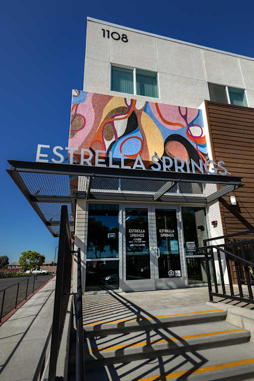The entrance to Estrella Springs with a colorful mural above it.