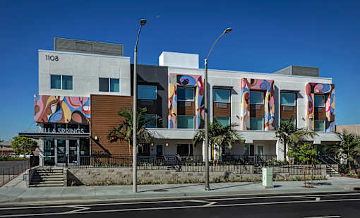 A modern building with a mural on the side and the number 1108 on the top left.