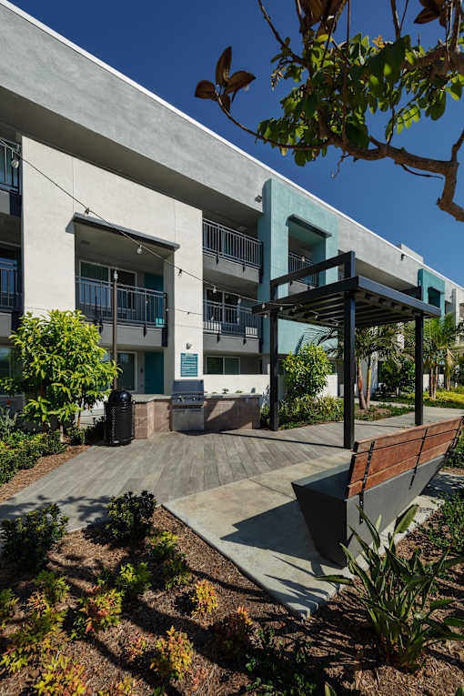 A modern building with a blue accent wall and a wooden bench in front.
