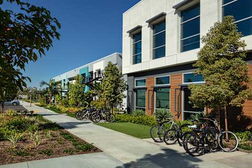 A row of bicycles are parked in front of a building.