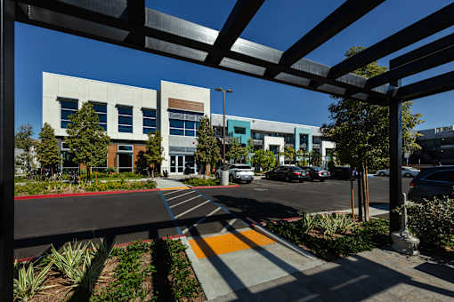 A modern building with a parking lot in front.