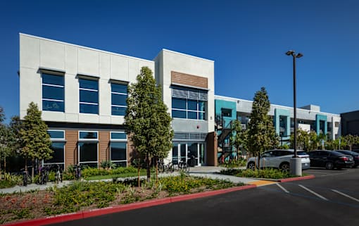 A modern building with a parking lot in front.