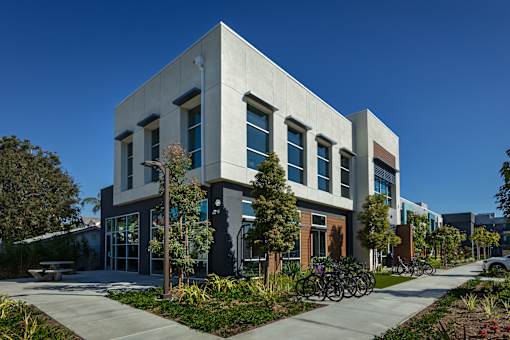 A modern building with a grey facade and a bicycle parked in front.