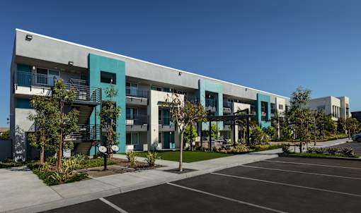 A modern building with a parking lot in front.
