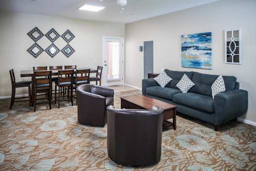 A living room with a grey couch and a brown coffee table.