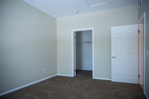 A room with a carpeted floor and a white door.