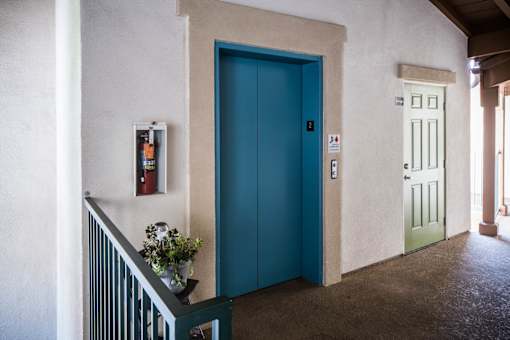 A blue door is in a white hallway.