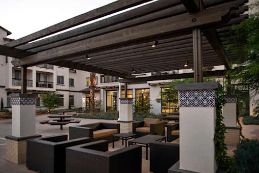 A patio with a table and chairs under a roof.