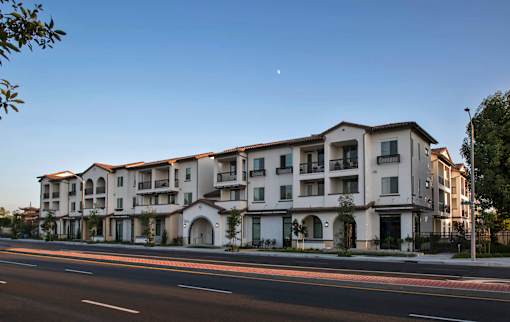 A large apartment building with a clear blue sky above it.