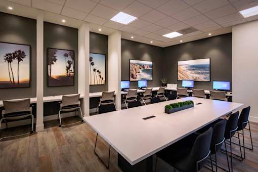 A conference room with a long table and chairs, and pictures on the wall.