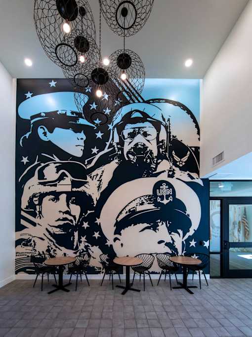 A mural of military personnel is displayed on a wall.