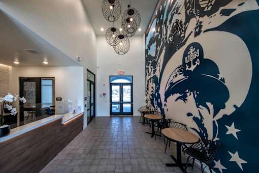 A hallway with a mural of a person wearing a hat and a white circle with stars on it.