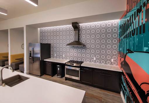A modern kitchen with a white countertop and black appliances.