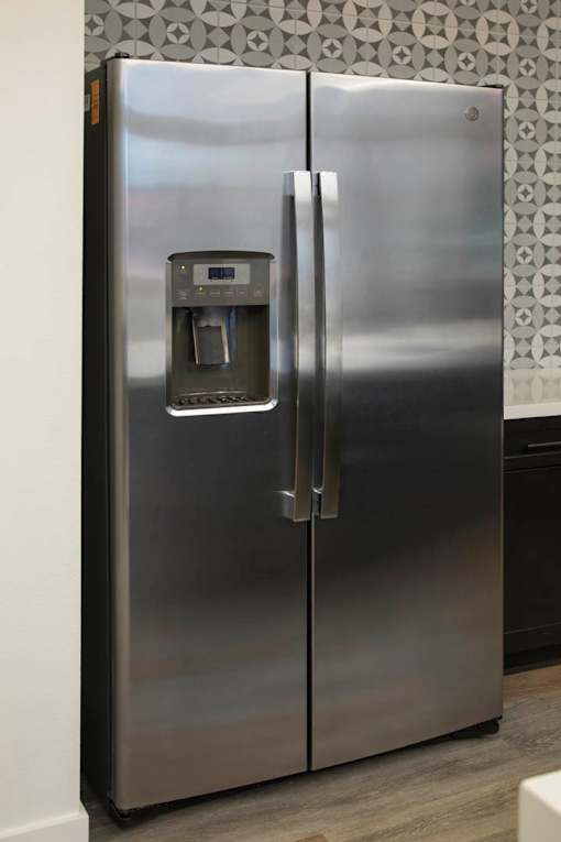A stainless steel refrigerator with a water and ice dispenser on the door.