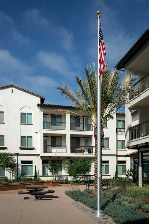 A white building with a flag on a pole in front.