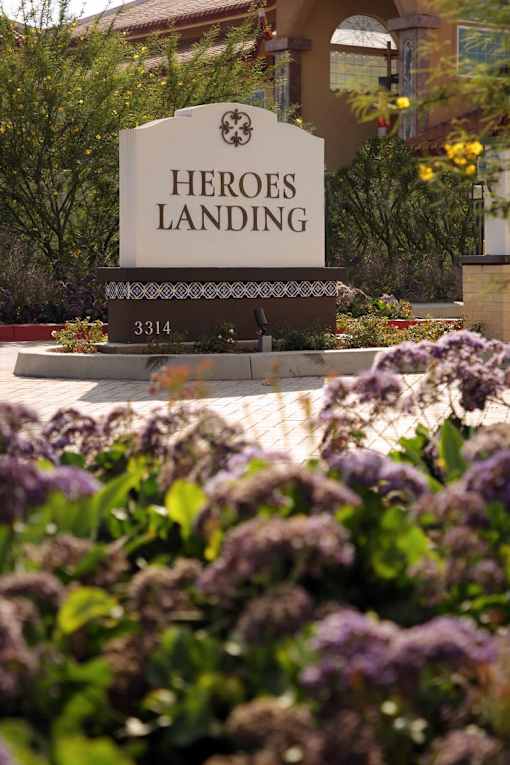A sign that says "HEROES LANDING" in front of a building.