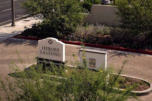 A sign that says Heroes Landing is in front of a building.