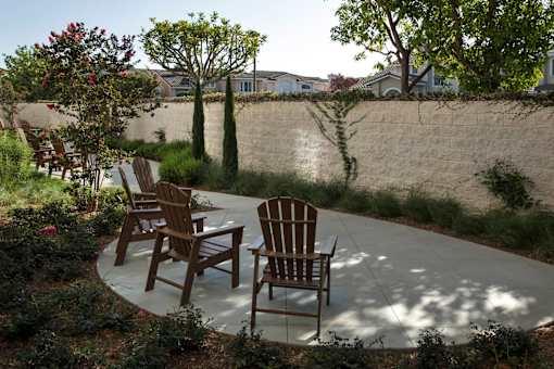 Three wooden chairs are placed on a patio.