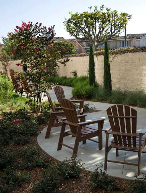 Three wooden chairs are placed on a patio.