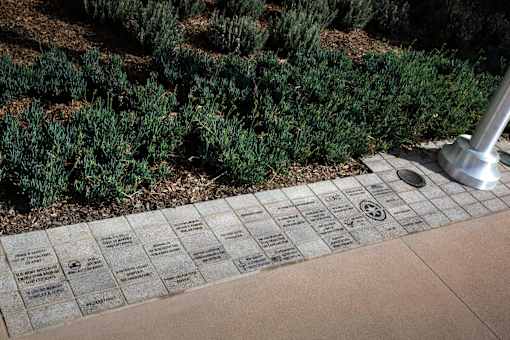 A plaque with names and symbols is placed on a ground.