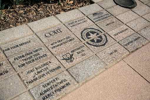 A brick with a star and a bird on it is part of a memorial.