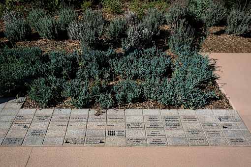A memorial with names engraved on stones surrounded by greenery.