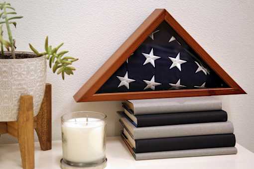 A white candle sits in front of a small American flag.