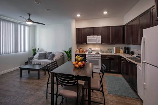 A modern kitchen with dark brown cabinets and a white refrigerator.