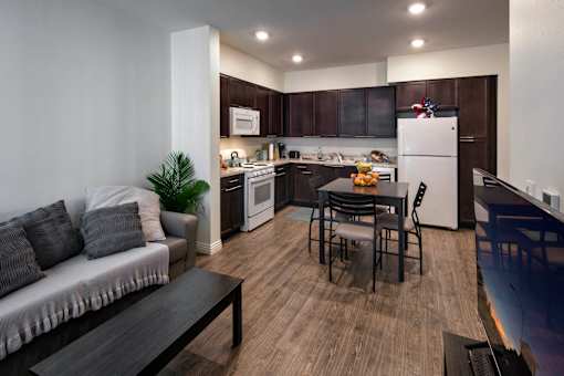 A modern kitchen with dark wood cabinets and a white refrigerator.