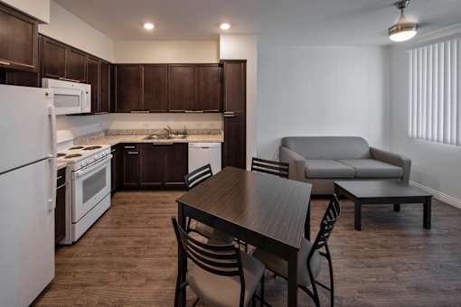 A kitchen with a table and chairs.