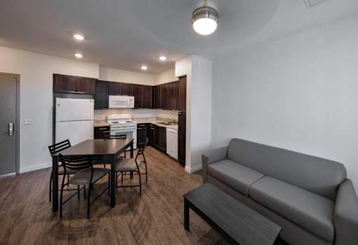 A modern kitchen with dark wood floors and white appliances.