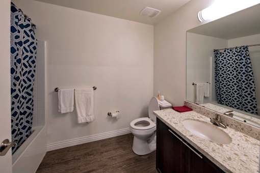 A bathroom with a toilet, sink, and shower.