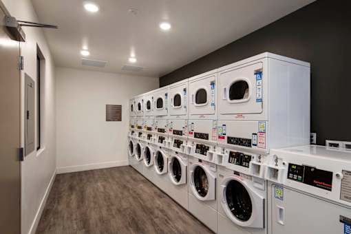 A row of white washing machines in a laundromat.