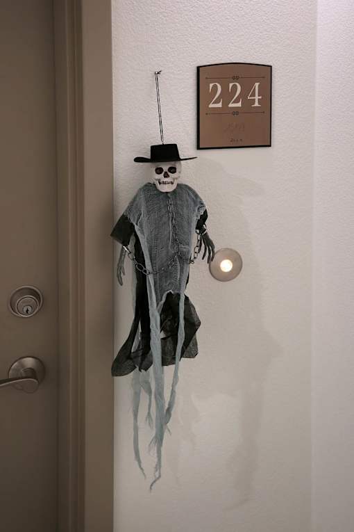 A door decorated with a skeleton figure and a number 224 on the wall.