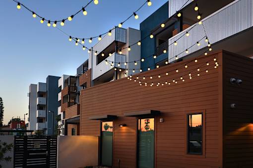A building with a brown facade and string lights hanging in front.