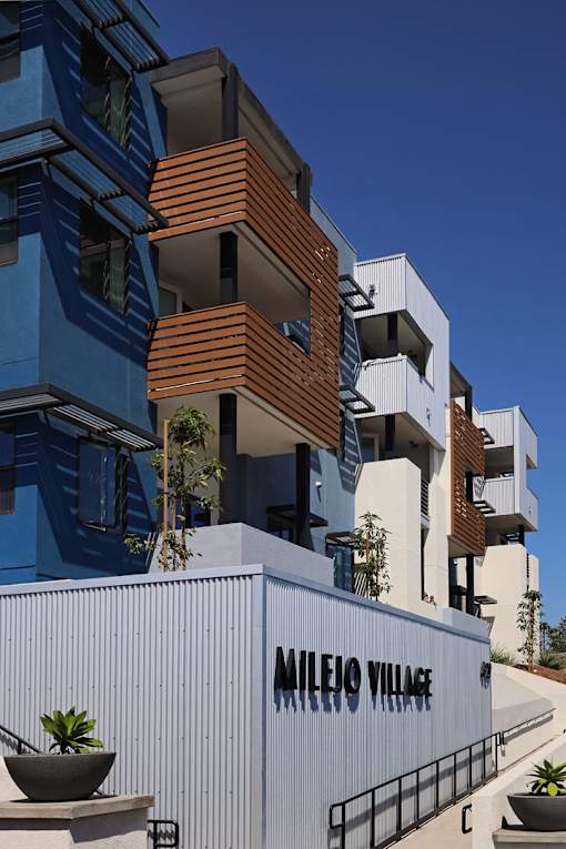 A modern building with the name "Mileio Village" on its facade.