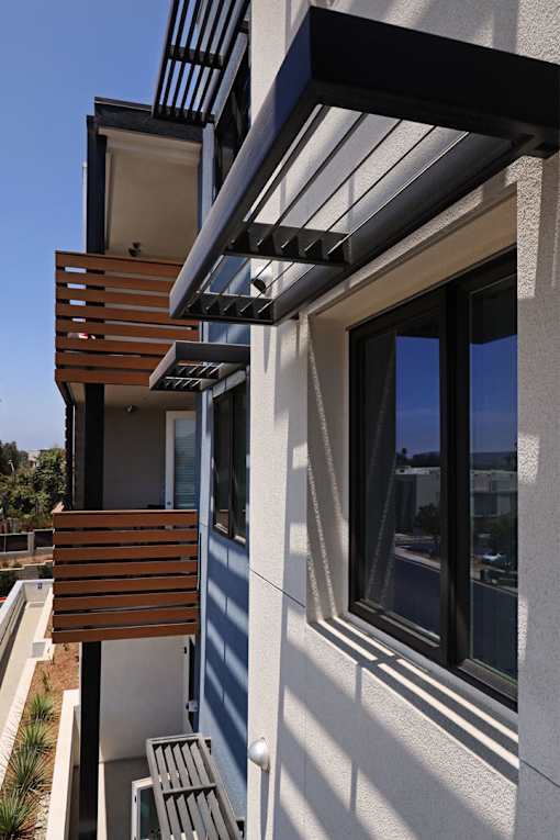 A modern house with a balcony and a wooden railing.