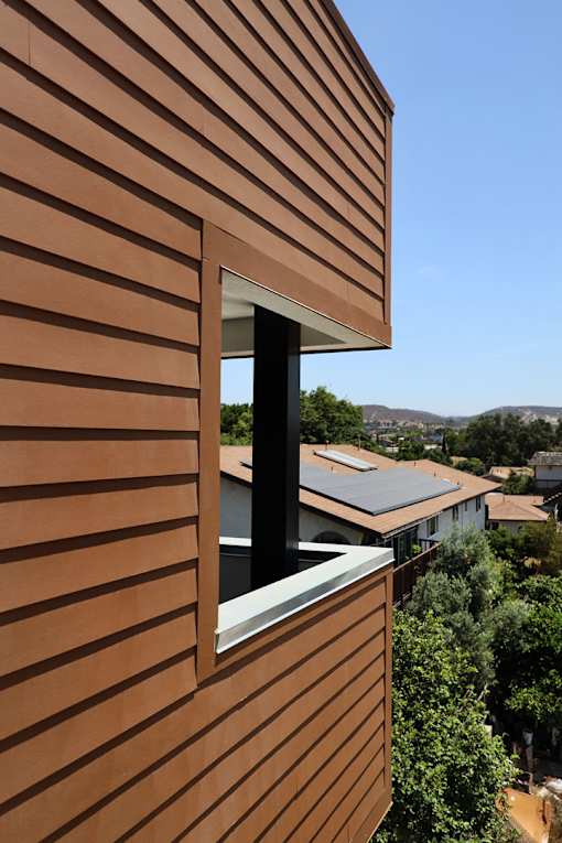 A brown building with a window and a view of the city.