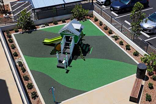 A playground with a green and grey slide.