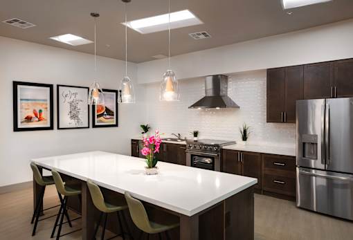 A modern kitchen with a white countertop and stainless steel appliances.